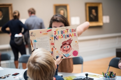 Kind leest boek "Jij bent een kunstenaar"