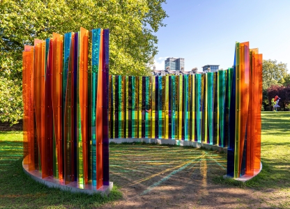 kunstwerk met kleurrijke rechtopstaande plastieken staven in park